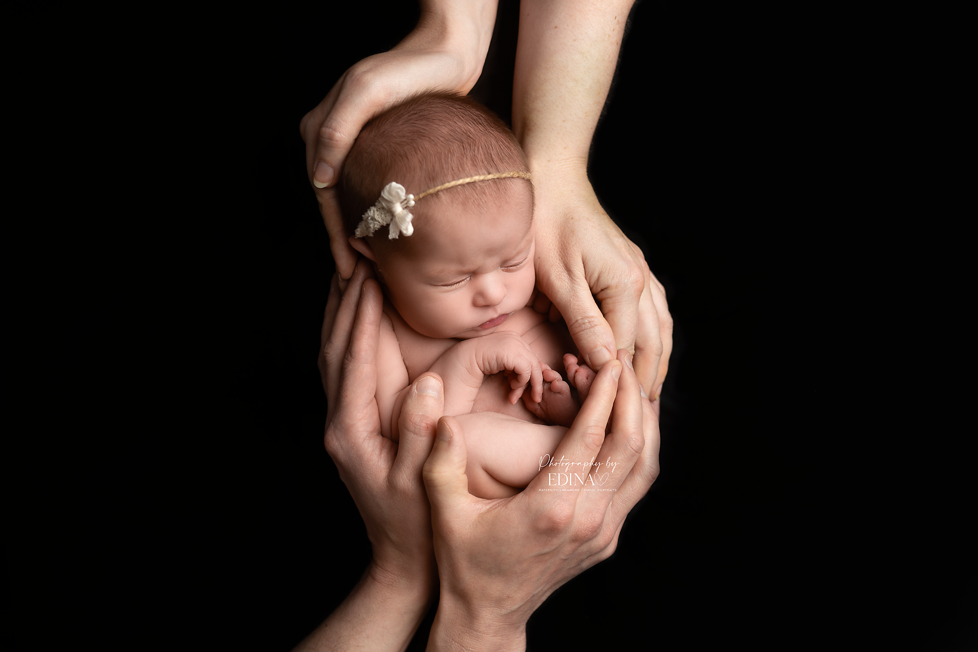 newborn baby girl held by her parents