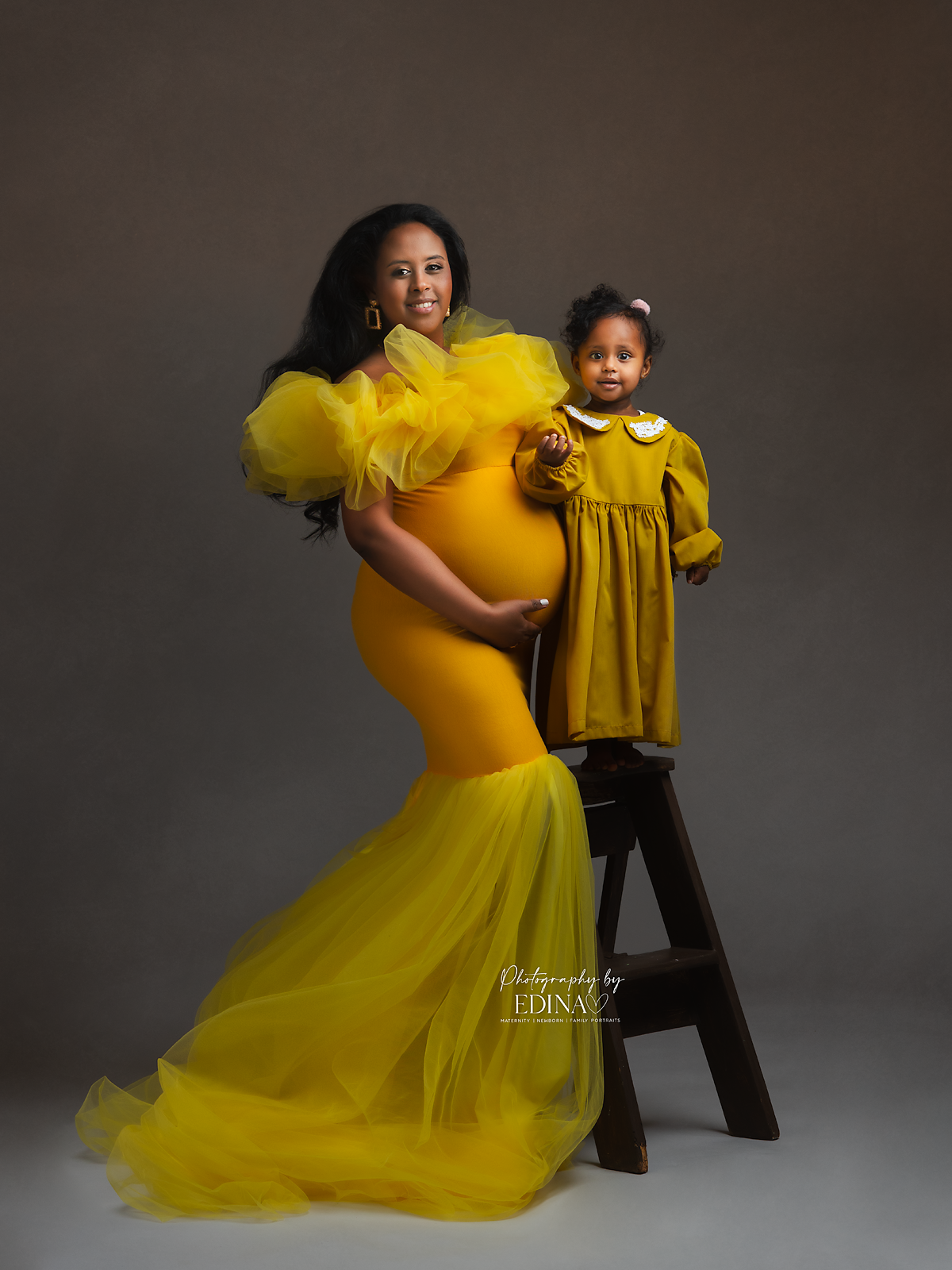 pregnant lady posing with her daughter