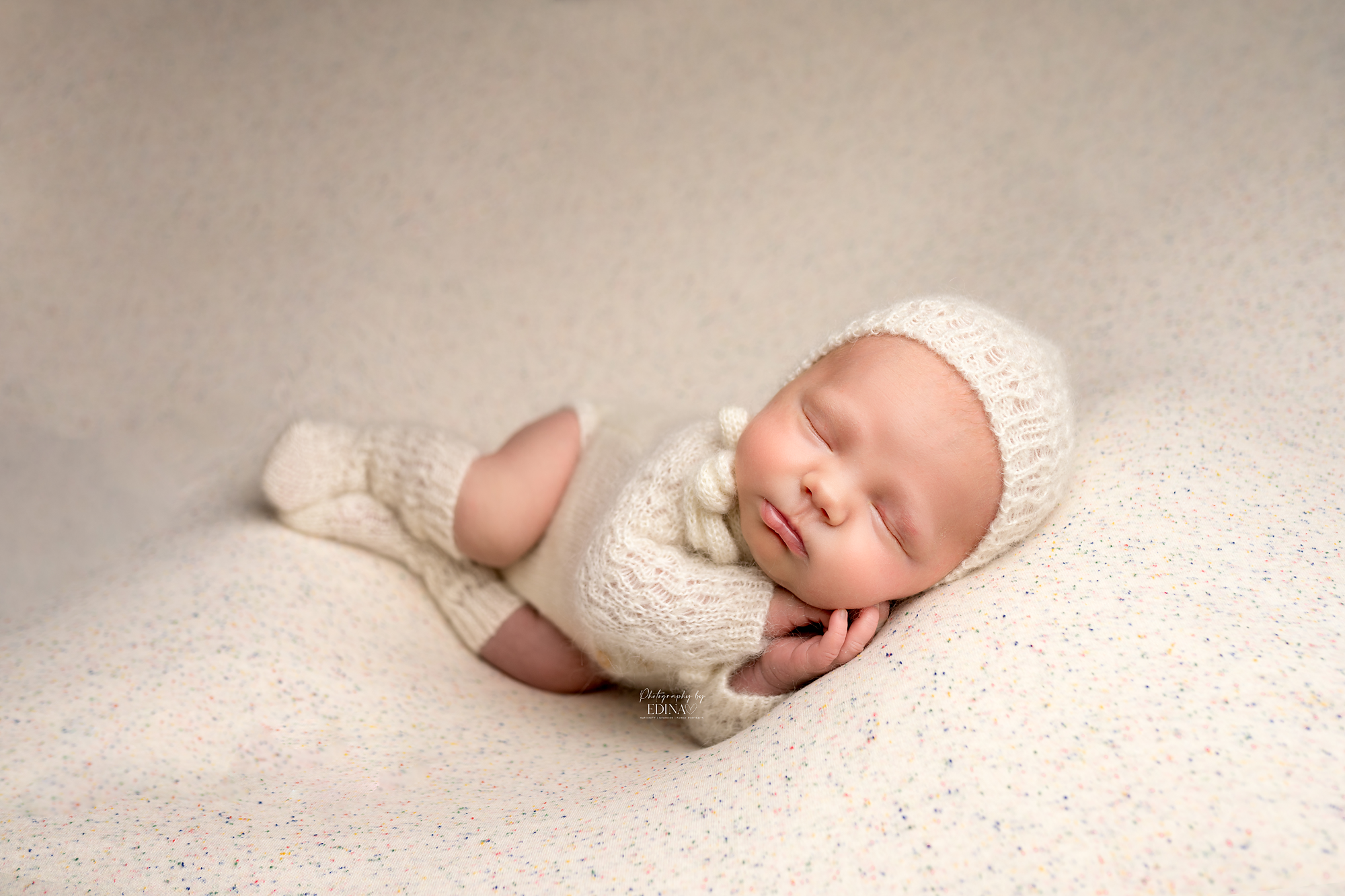 newborn baby in white bonnet sleeping on blanket by Newborn and maternity photographer in York